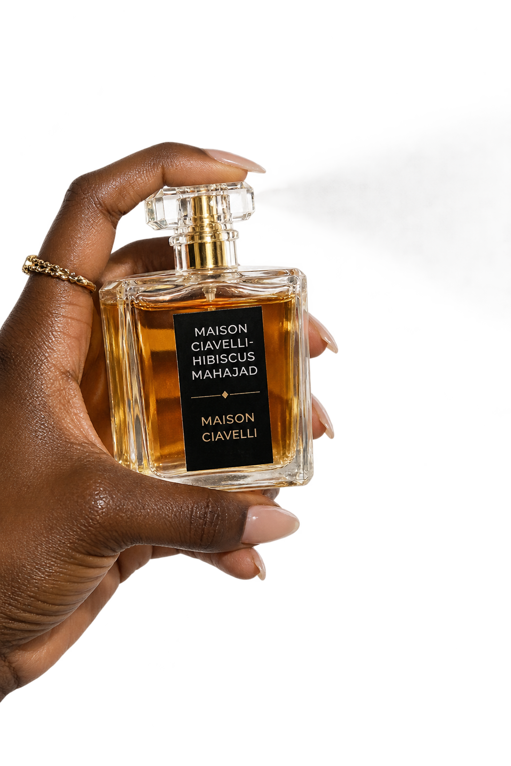 A hand spraying a bottle of Hibiscus Mahajad perfume oil